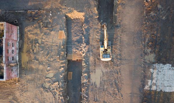 In an aerial photograph, a backhoe is seen next to large burial trenches and abandoned buildings on Hart Island, located in the Long Island sound, off the coast of the Bronx, New York, USA, on 10 April 2020. EFE/EPA/Justin Lane